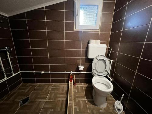 a bathroom with a toilet and a window at Resort Zevs Komovi in Trešnjevik