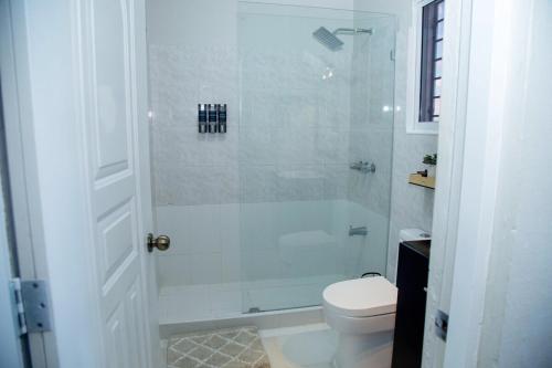 Un baño blanco con ducha y WC. en Luxury 2 bedroom Apartment, en Santiago de los Caballeros