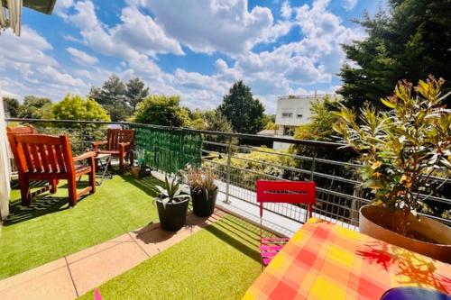 d'un balcon avec une table, des chaises et de la pelouse. dans l'établissement Apartment with terrace and pool, à La Rochelle