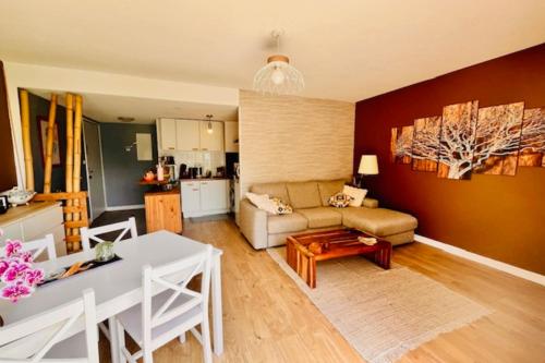 un salon avec un canapé et une table dans l'établissement Apartment with terrace and pool, à La Rochelle