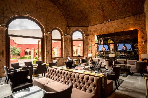 a large room with a bar with chairs and televisions at Hilton San Luis Potosi in San Luis Potosí