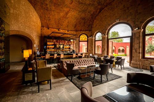 a restaurant with a bar and tables and chairs at Hilton San Luis Potosi in San Luis Potosí