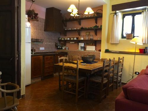 a kitchen with a wooden table and chairs in a room at LAS CUATRO CALLES Bis in Piedralaves