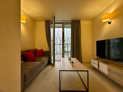 a living room with a couch and a flat screen tv at Luxury One Bedroom Flat next to Wembley Stadium in London