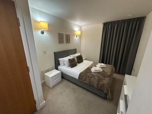 a hotel room with a bed and a window at Luxury One Bedroom Flat next to Wembley Stadium in London
