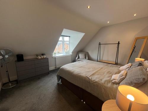 a bedroom with a bed and a dresser and a window at Fairfield Cottage Rooms in Inverness
