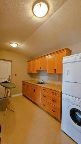 a kitchen with a washer and dryer in it at Misty Mountain Inn & Suites in Grande Cache