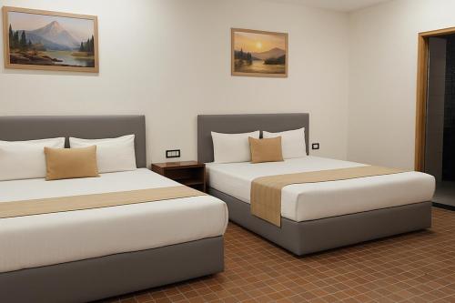 una camera d'albergo con due letti in una stanza di In GOA Three Bedroom Penthouse with Kitchen a Candolim