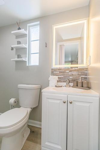 a white bathroom with a toilet and a sink at Cozy Tiny Home for 2! Short drive to the Beach! in Myrtle Beach