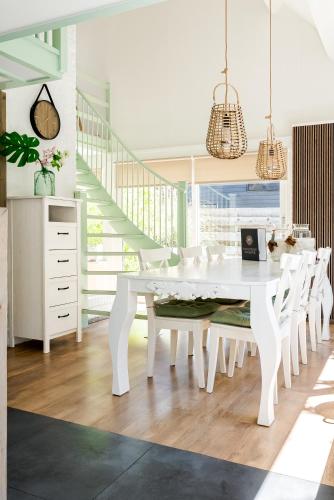 a white dining room with a white table and chairs at -Duna Lago- nabij het meer, restaurants en Keukenhof in Noordwijkerhout