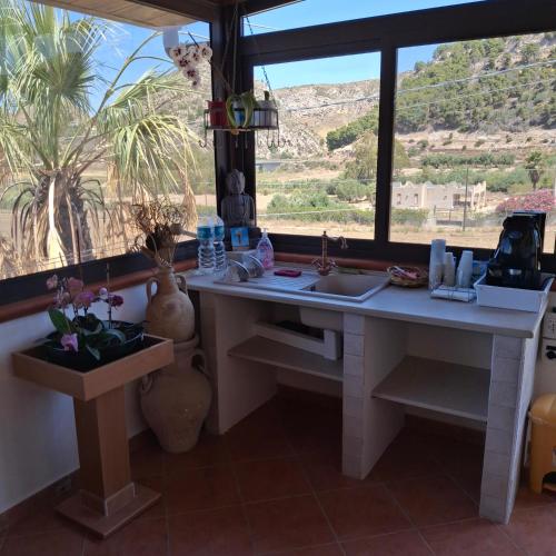 a kitchen with a desk and a large window at La Foggia seaside paradise in Siculiana