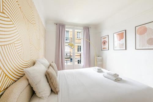 une chambre blanche avec un lit et une fenêtre dans l'établissement Appartement Neuilly Chic, Vivez l'Élégance - II, à Neuilly-sur-Seine