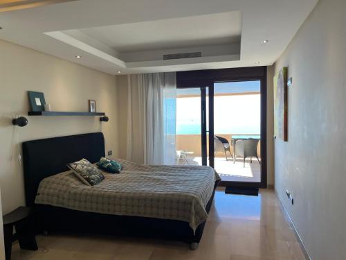 a bedroom with a bed with a view of the ocean at Bahia De La Plata Seafront in Estepona