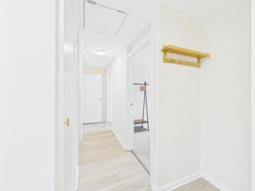 a hallway with white walls and a wooden floor at MODERN 2 BED BUNGALOW SLEEPS 4 Pet friendly in Calne