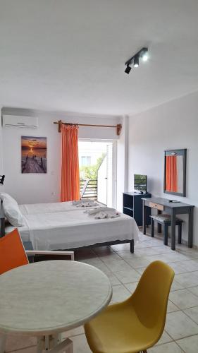 a bedroom with a bed and a table and chairs at Kalliopi Studios - Apartments in Kato Daratso