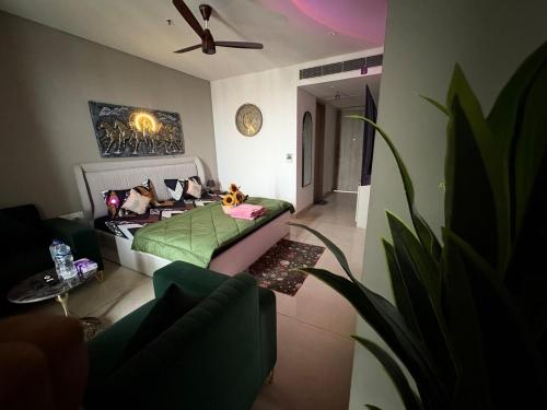 a bedroom with a bed with a green blanket at The Twilight Flora in Gurgaon