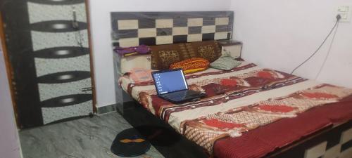 a bedroom with a bed with a laptop on it at jakusst home stay in Gwalior