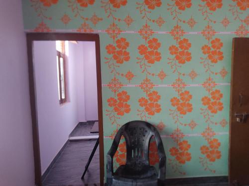 a mirror in front of a wall with orange flowers at jakusst home stay in Gwalior