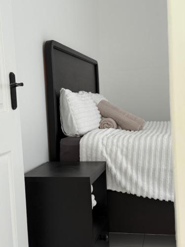 a bedroom with a bed with white sheets and a table at 268 Self-catering Apartments in Swakopmund