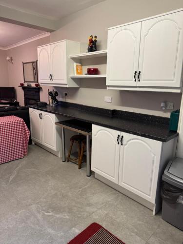 a kitchen with white cabinets and a black counter top at Reelin Bar Holiday Accommodation in Cloghan