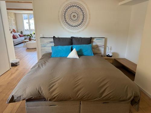 une chambre avec un grand lit avec des oreillers bleus dans l'établissement Duplex with Terrace Bordeaux - Light & View, à Bordeaux