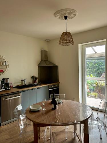 une cuisine avec une table avec une bouteille de vin dans l'établissement Run'Albi - MAISON DE VILLE CLIMATISE - CENTRE VILLE - 2 CHAMBRES, à Albi