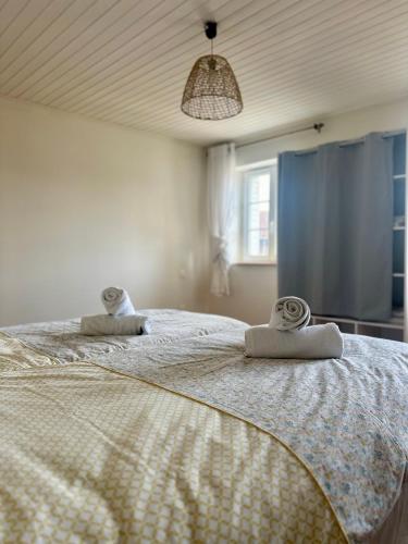 Un dormitorio con una cama grande con toallas. en Run'Albi - MAISON DE VILLE CLIMATISE - CENTRE VILLE - 2 CHAMBRES, en Albi