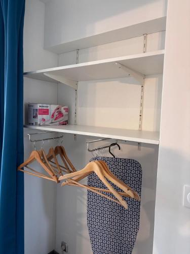 Elle comprend un dressing avec des étagères et des cintres blancs. dans l'établissement Studio rénové marche Forville Cannes, à Cannes