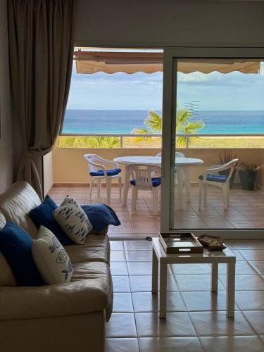 a living room with a couch and a view of the ocean at Playa Jandia Fuerteventura in Morro del Jable