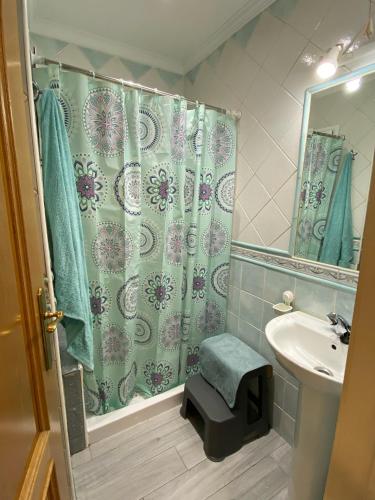 a bathroom with a shower curtain and a sink at Arcaro Beach in Málaga