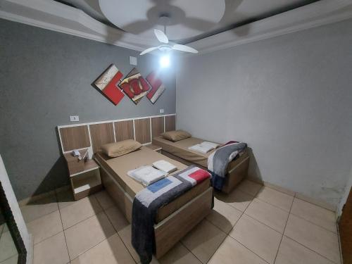 a room with two beds and a ceiling fan at Hotel Luar in Sao Paulo