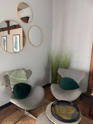 two chairs and a table in a room with mirrors at Barwny Zakątek in Augustów