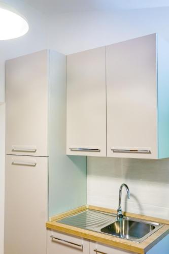 a kitchen with white cabinets and a sink at Il Rifugio del Cuore in Scanno