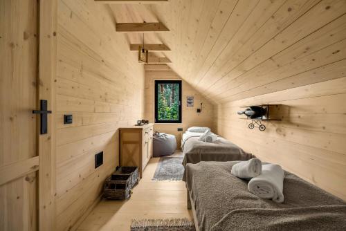 two beds in a room with wooden walls at Modern Farmhouse Zegrze with Sauna - by Rentujemy in Beniaminów