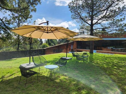a group of chairs and tables with umbrellas at El CIELO HOTEL BOUTIQUE in San Miguel Ajusco