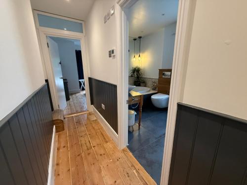 un corridoio che conduce a un bagno con servizi igienici di Seaweed Suite, secluded seaside stay with garden view a Newquay