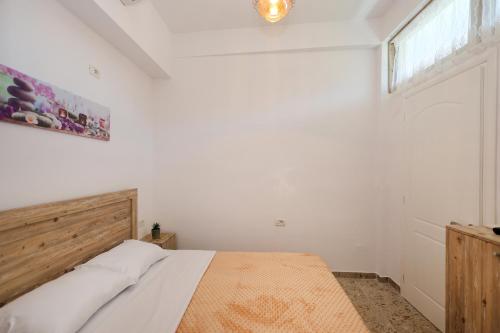 a white bedroom with a bed and a window at Vila Spahiu in Berat