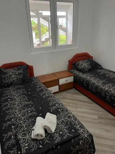 a bedroom with two beds and a window at N&D Apartment in Kotor