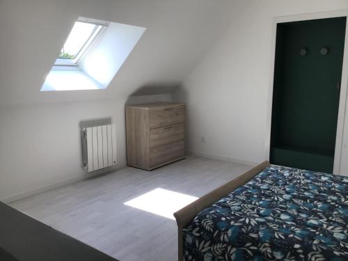 a bedroom with a bed and a dresser and a window at Maison à la campagne, proche de Guingamp in Ploumagoar