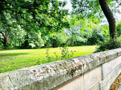 a stone wall with a park in the background at Maison La Galeze 