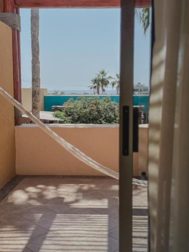 a room with a view of the ocean from a balcony at Hotel Los Patios in Cabo San Lucas