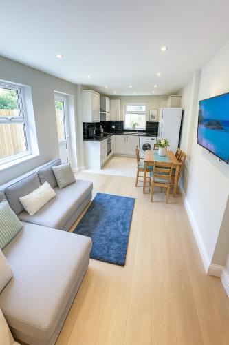 a living room with a couch and a table at 2-Bedroom Garden Flat - Modern, Bright - A in London