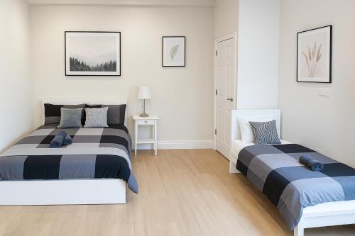 two beds in a bedroom with white walls at 2-Bedroom Garden Flat - Modern, Bright - A in London
