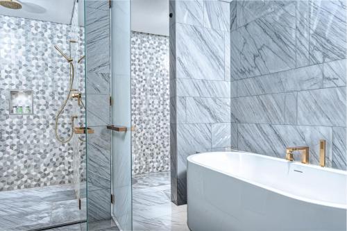 a bathroom with a white tub and a shower at FIVE Palm Jumeirah Premier Apartments in Dubai