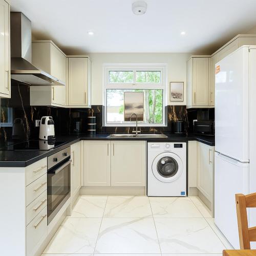 a kitchen with a sink and a washing machine at 2-Bedroom Garden Flat - Modern, Bright - A in London
