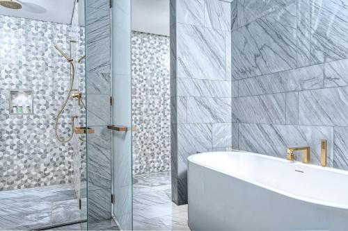 a bathroom with a white tub and a shower at FIVE Palm Jumeirah Premier Apartments in Dubai