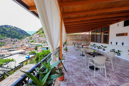 a balcony with tables and chairs and a view at Vila Spahiu in Berat