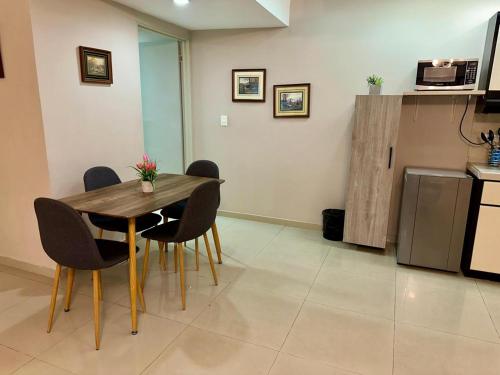 a dining room with a wooden table and chairs at Apartaestudios - Torre de Cali in Cali