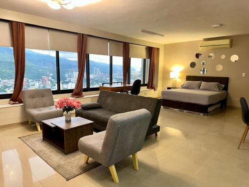 a bedroom with a bed and a living room with a couch at Apartaestudios - Torre de Cali in Cali