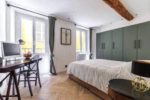 une chambre avec un lit et un bureau avec un ordinateur dans l'établissement Appartement de charme en plein coeur du vieux Nice, à Nice